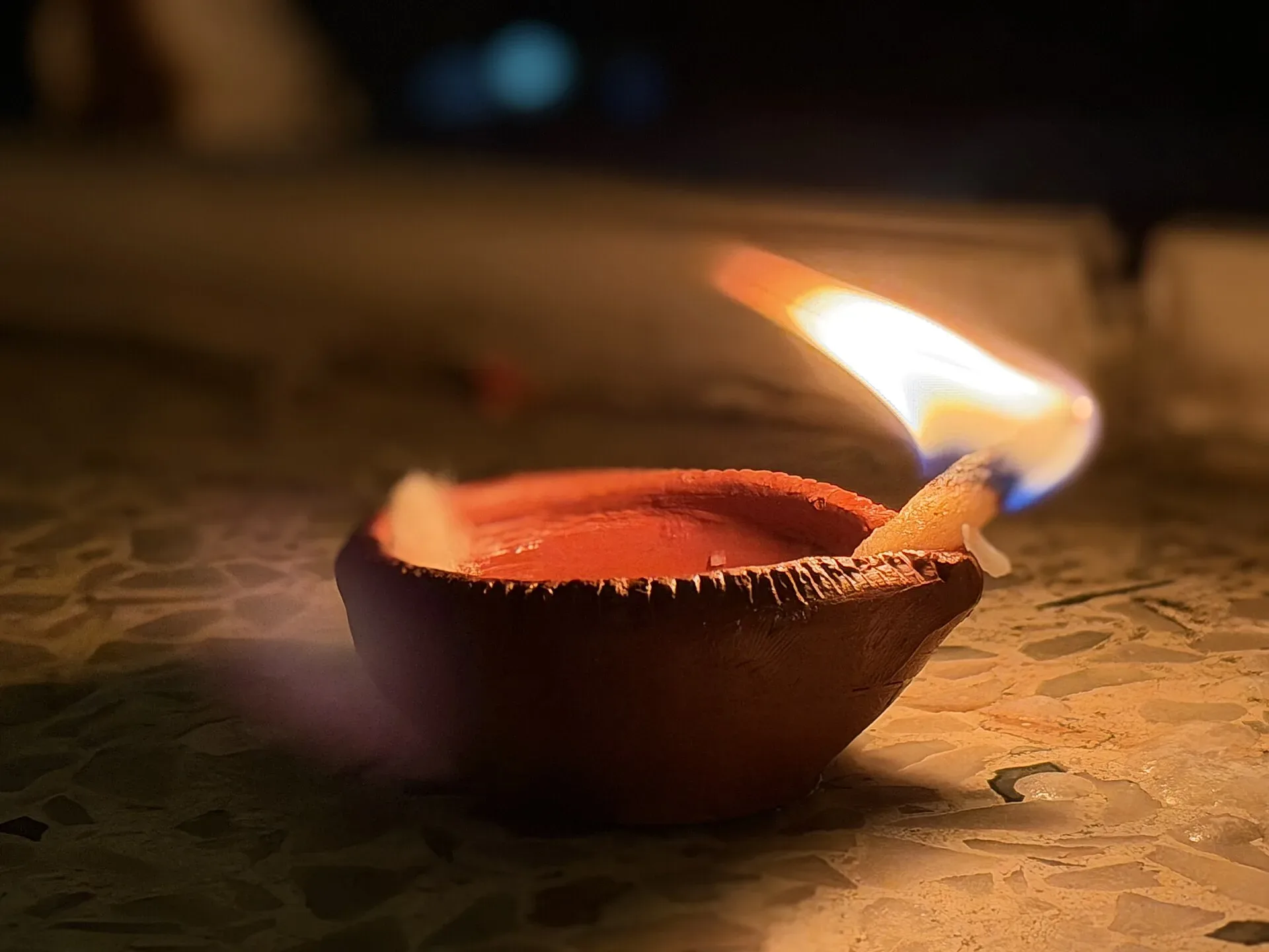 A lit earthen diya lamp