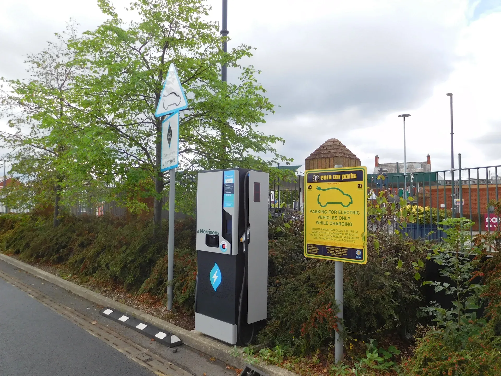 An electric vehicle charging point beside a car park
