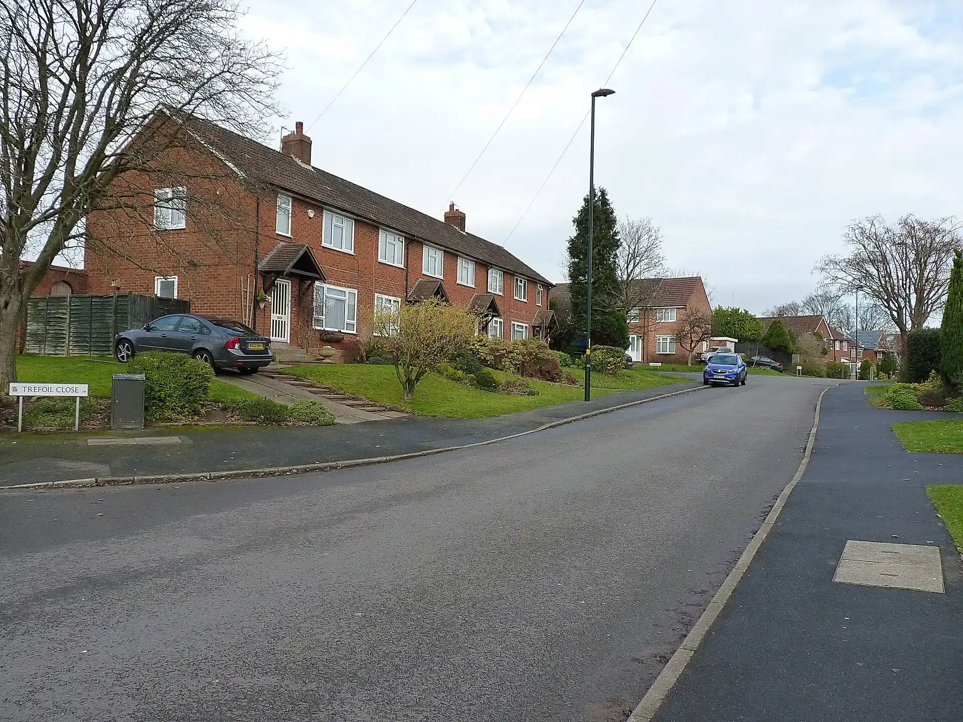 A row of red-brick semi-detached houses on a quiet residential road in Northfield