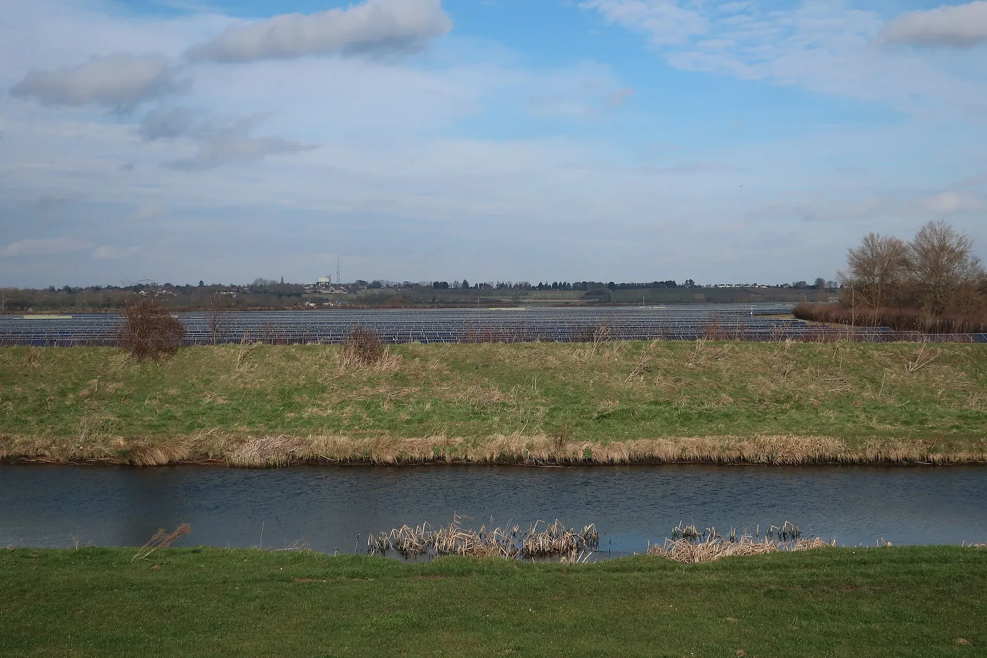 Rows of solar panels in a field beside the River Great Ouse